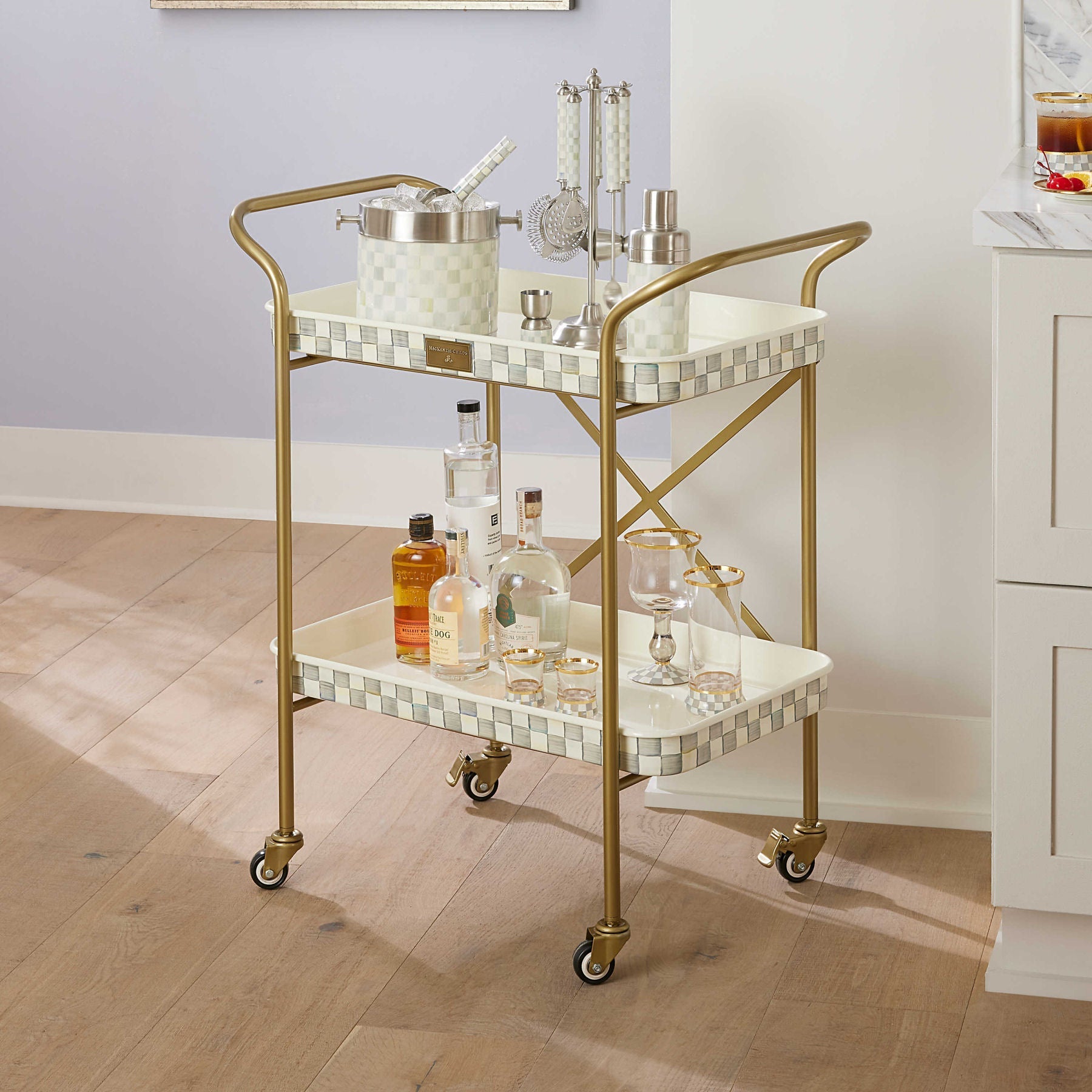Dvoupatrový kuchyňský vozík Sterling Check od MacKenzie-Childs, s tácy s černobílým kostkovaným vzorem a mosazným rámem, Waterfall Bathrooms.
