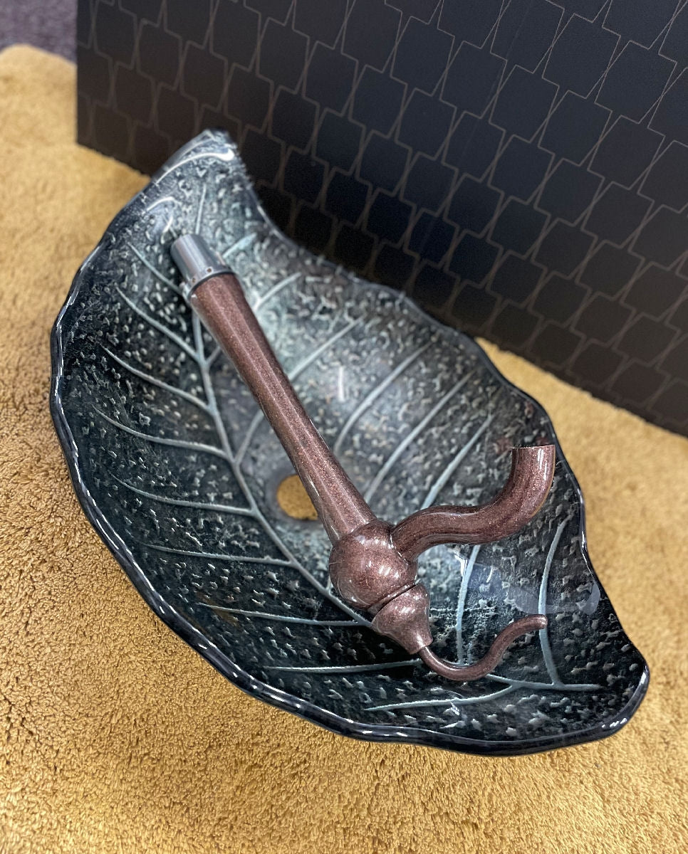 Šedé umyvadlo ve tvaru listu s měděnou baterií