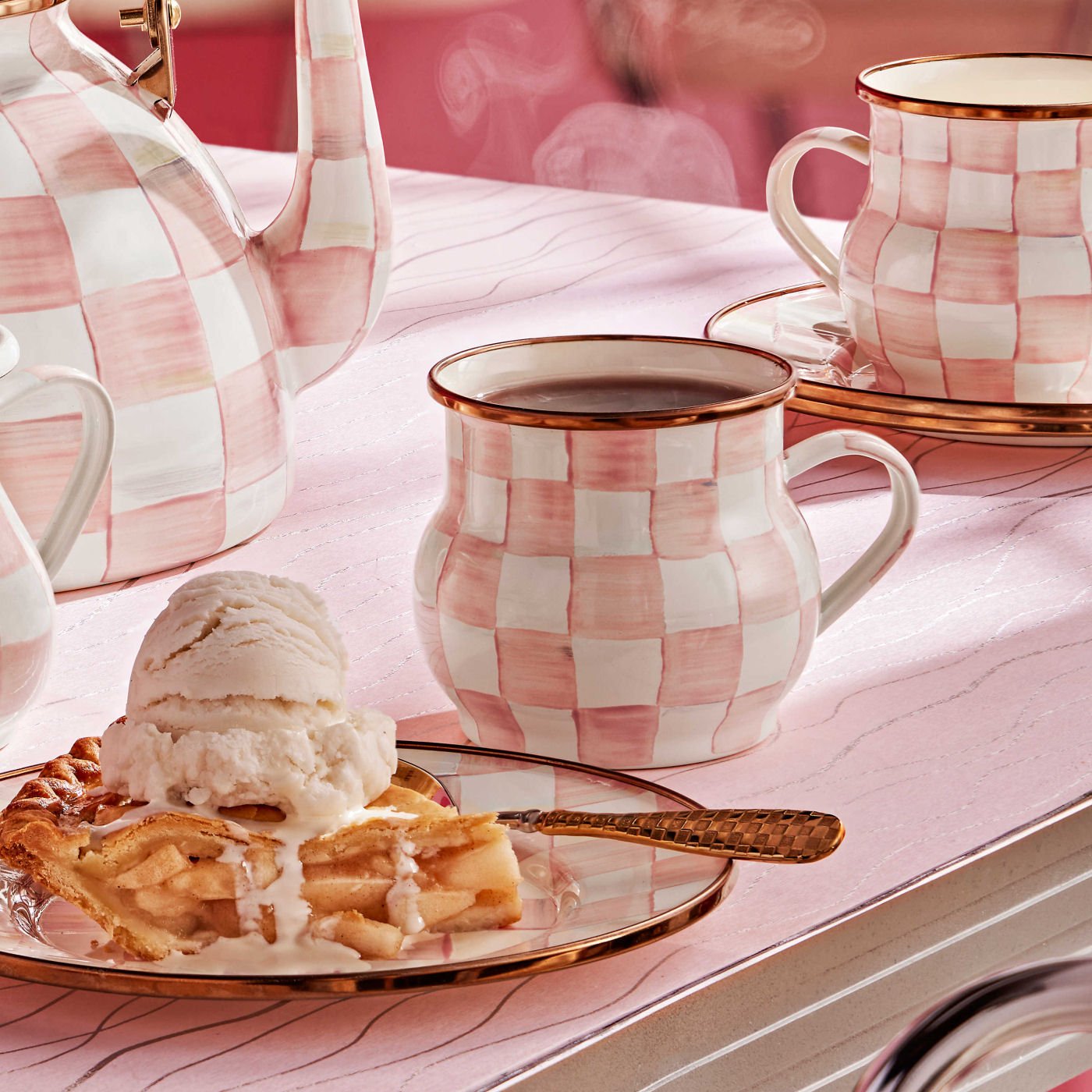 Smaltovaný hrnek Rosy Check od MacKenzie-Childs s růžovým kostkovaným vzorem a bronzovým lemem, Waterfall Bathrooms.