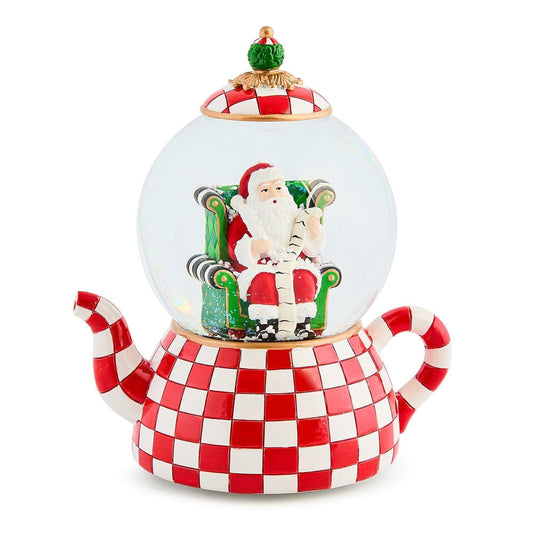 Vánoční sněžítko MacKenzie-Childs ve tvaru čajové konvice s červeno-bílou kostkou, na které sedí Santa Claus v křesle.