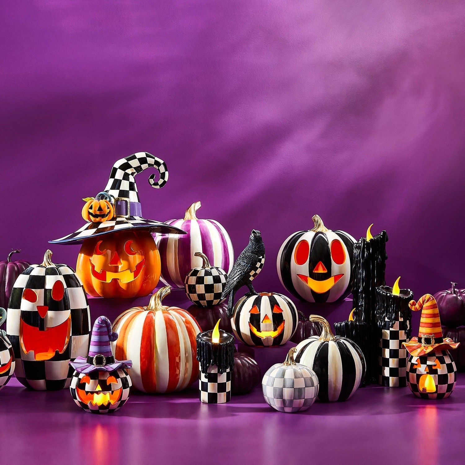 Svítící halloweenská dýně Happy Jack s fialovým kloboukem od MacKenzie-Childs, pryskyřice, černobílý šachovnicový vzor Courtly Check, LED světlo na baterie, Waterfall Bathrooms.
